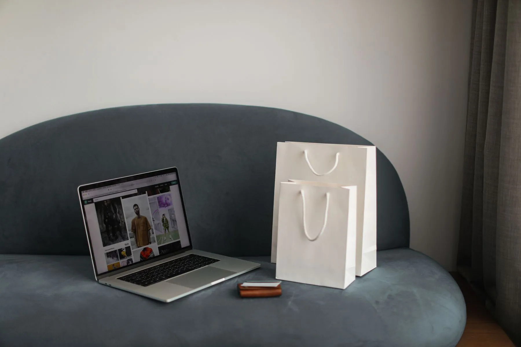 Online store on a laptop beside a shopping bag