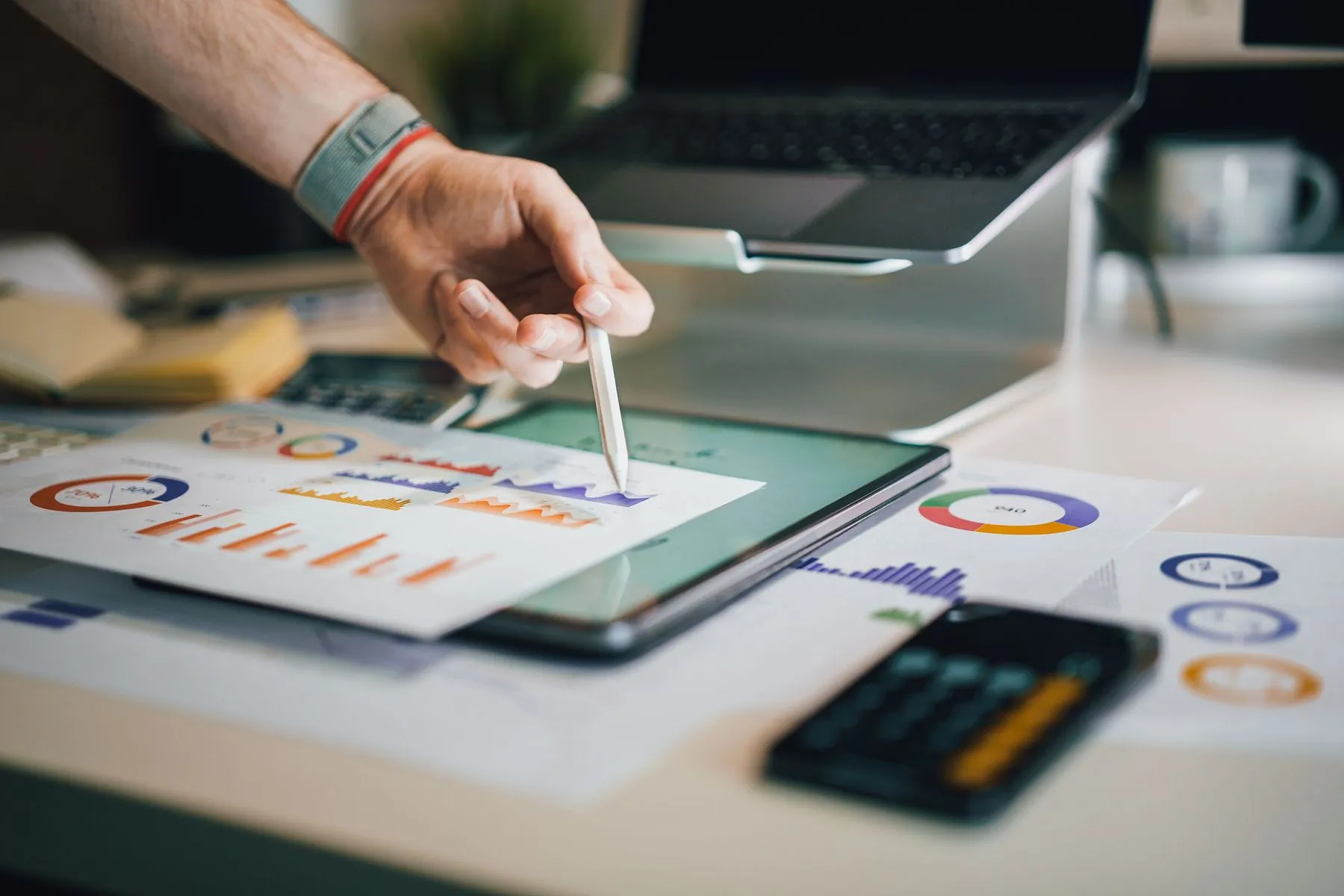 Analytics charts reviewed on a tablet beside printed reports